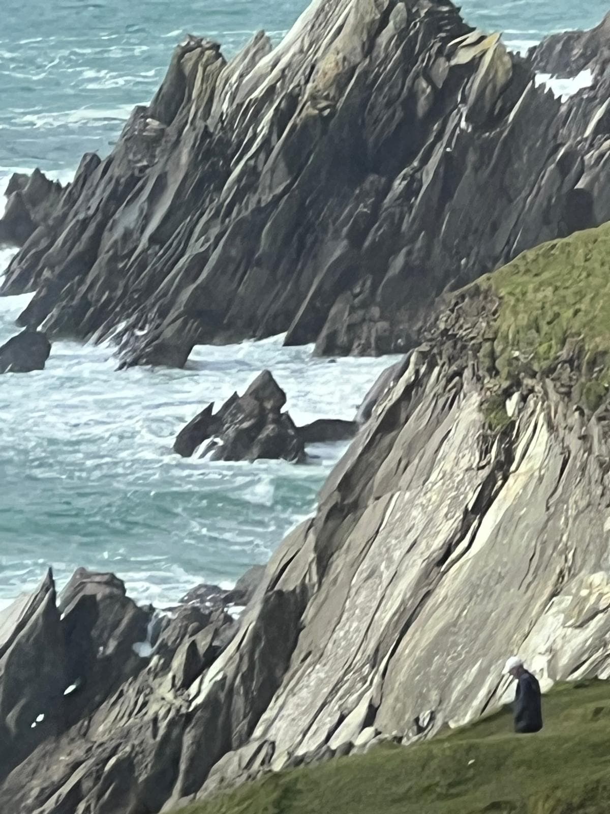 Dramatic columnar basalt cliffs rise from turquoise Atlantic waters along Ireland's rocky coastline