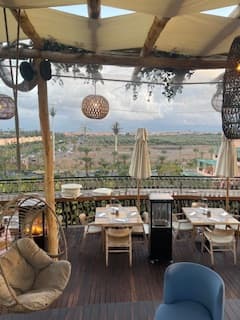 Katherine Friedman enjoys a meal on a rooftop terrace overlooking the Atlas Mountains and Moroccan valley landscape